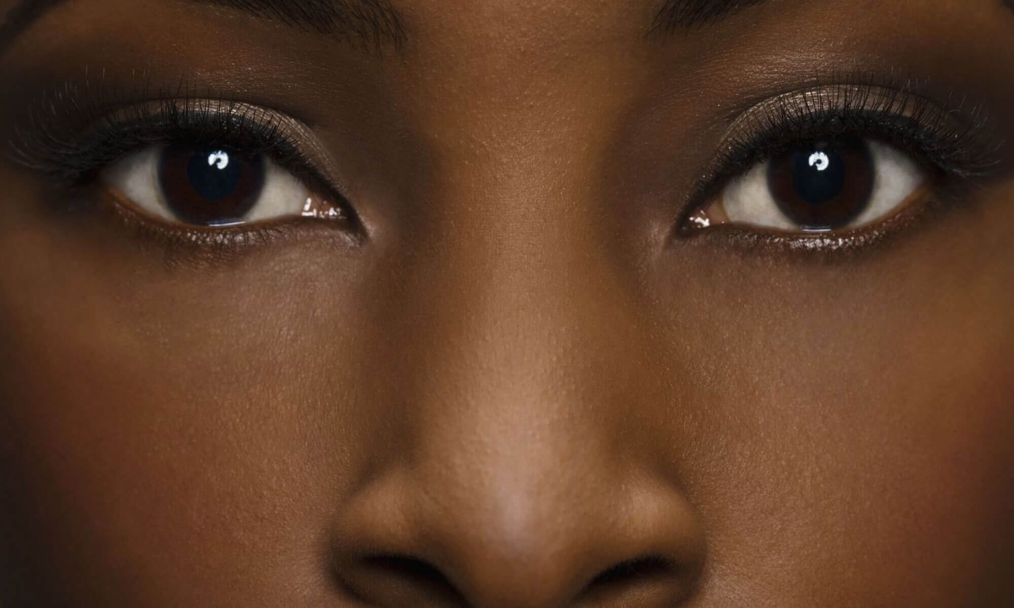 #descriçãodaimagem Close em rosto de mulher negra com expressão facial neutra